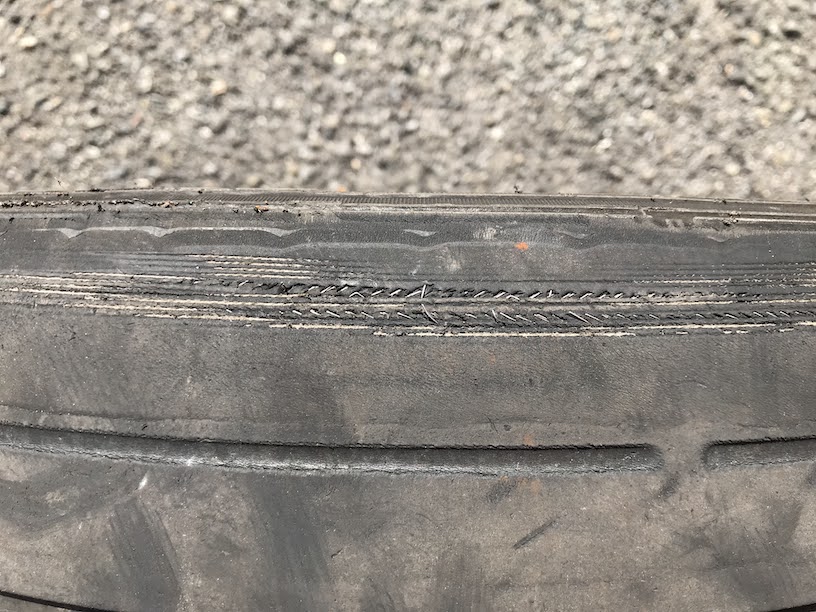 偏摩耗によってタイヤの中にあるワイヤーが見えている状態です。 バーストする危険があるので早めに交換しましょう。